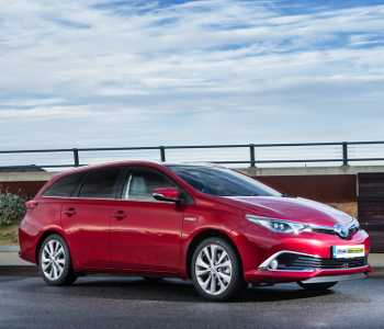 2018 Toyota Auris Touring red estate car for sale, shown parked on a wet street with a cloudy sky and fence in the background. Ideal addition to your taxi fleet.