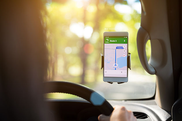 a lady driver looking at Google Maps on her phone while driving