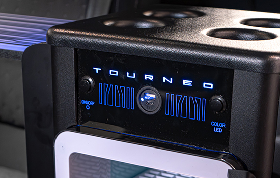 Close-up of a TOURNEO control panel with blue LED lights, an on/off switch, colour LED button, and cup holders, designed for the Ford Tourneo Custom Taxi.