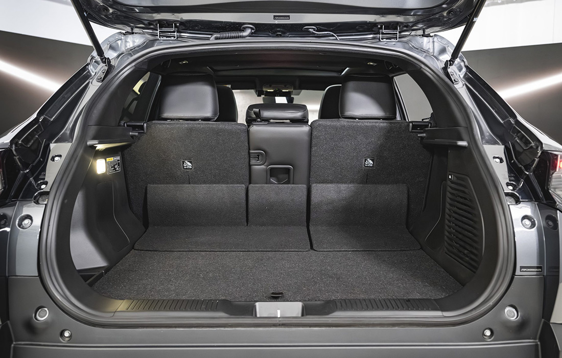 Open boot of SUV with rear seats upright, showing a spacious and clean black interior luggage area, ideal for taxi use; small light on left side for added visibility.