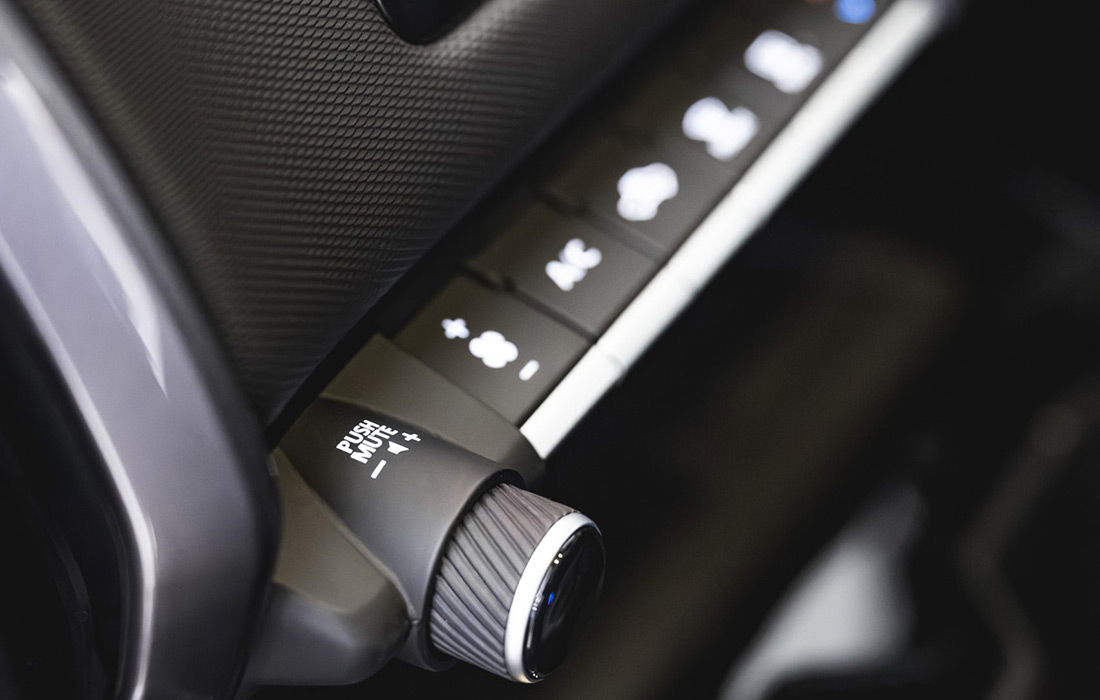 Close-up of a taxi’s control panel with multiple buttons and a rotary knob marked PUSH NORMAL. The panel features both textured and smooth finishes, with several illuminated icons visible.