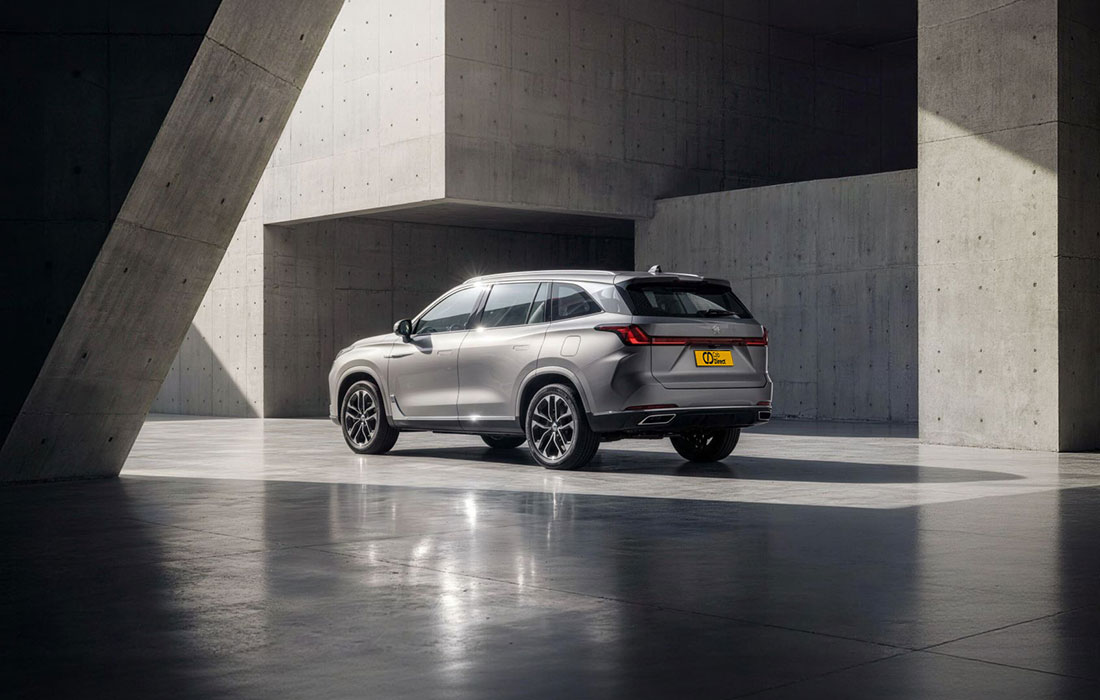 A silver SUV taxi parked in a modern concrete structure with striking lighting, dramatic shadows, and geometric architectural lines. The vehicle is shown from the rear and side, emphasising its design and professional appearance for taxi sales.