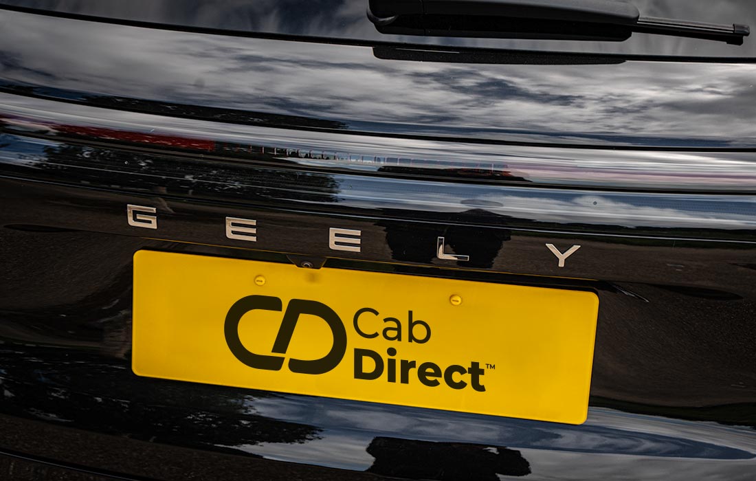 Close-up of a black Geely taxi rear with a yellow Cab Direct licence plate, featuring reflective shine that captures the sky and trees.