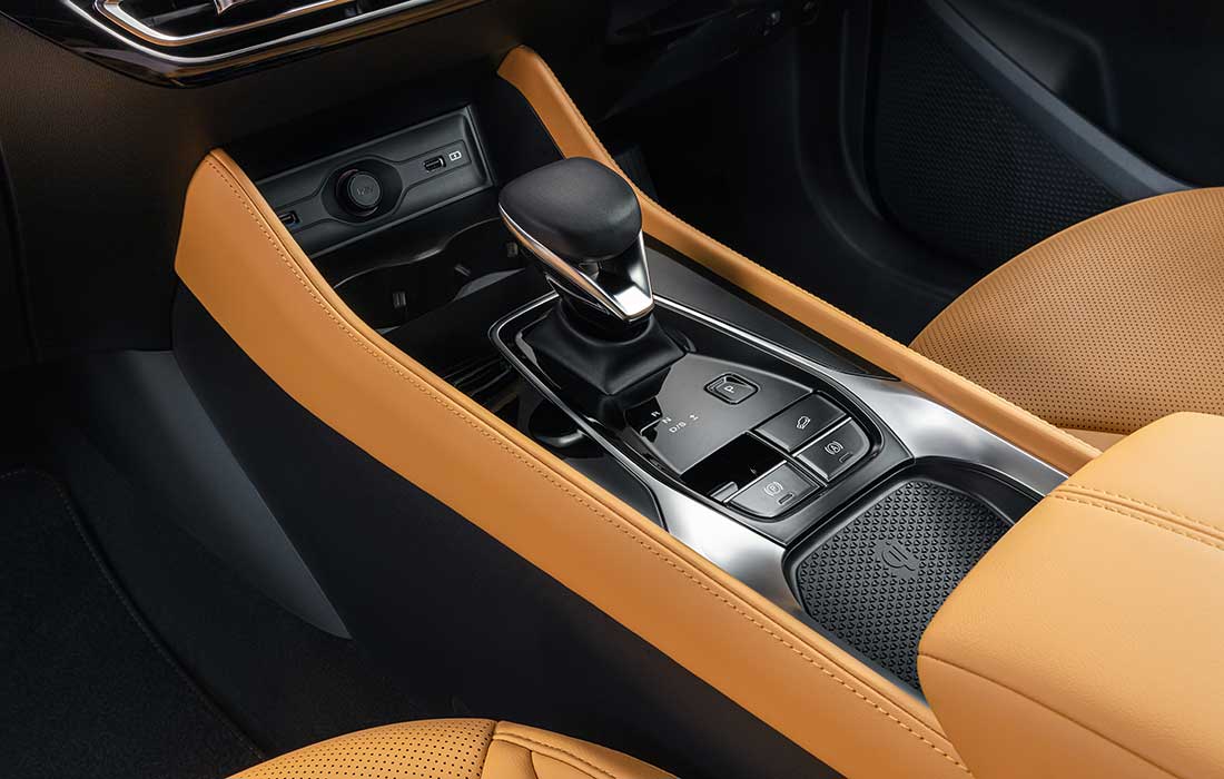 Interior view of a taxi centre console featuring a gear selector, electronic parking brake switch, and a wireless charging pad.