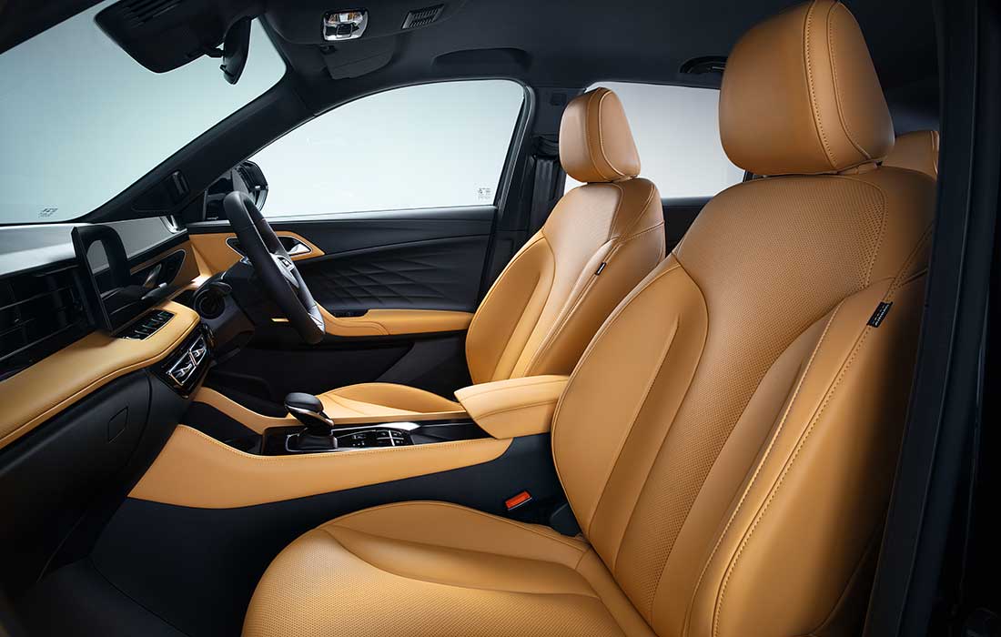 Interior view of a taxi with tan leather front seats and a black dashboard.