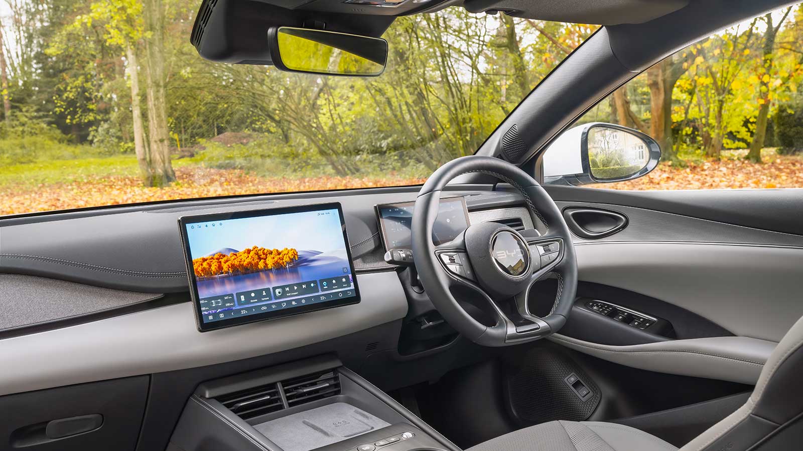 Interior of a BYD taxi featuring a digital touchscreen dashboard, steering wheel, and front cabin view.