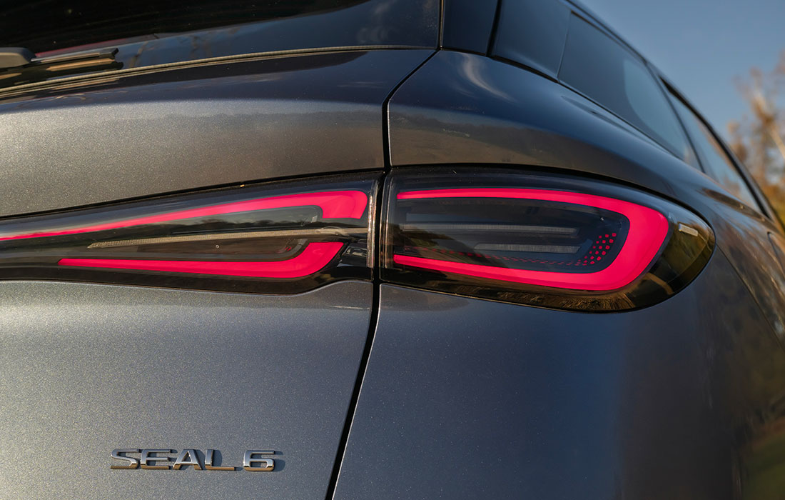 Close-up of the rear tail light and Seal 6 badge on a grey taxi.