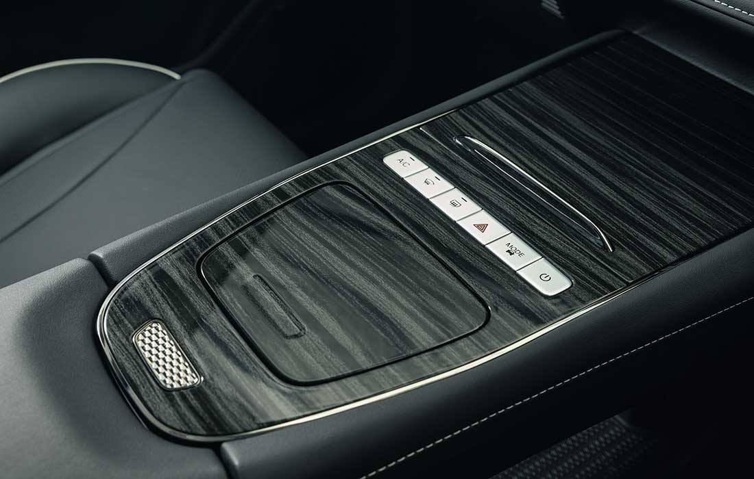 Taxi interior centre console featuring wood-grain trim, climate control, and mode buttons.
