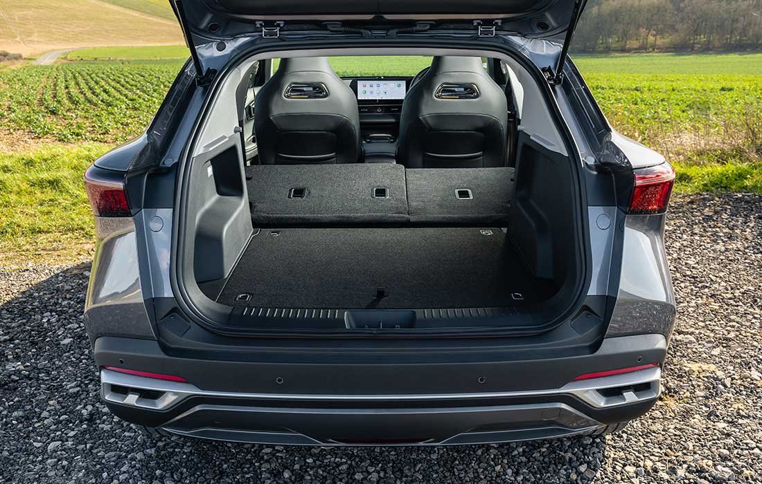 Rear view of a grey SUV taxi with its boot open, displaying the luggage area and rear seats.